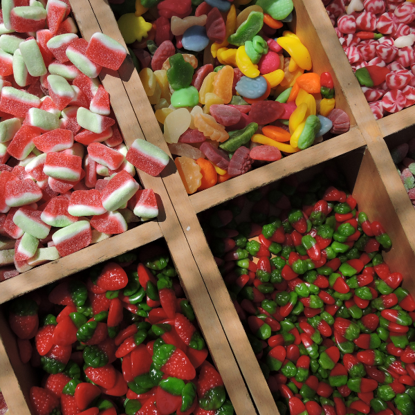 image: bins of a selection of fruity, brightly colored candies, gummies, skittles, etc. 