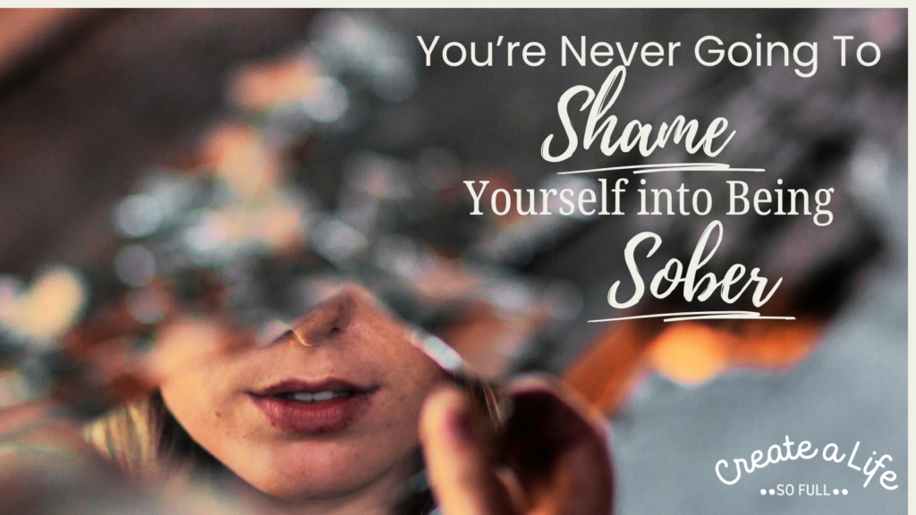 Image: A blurry background, with a hand holding a mirror in focus. The reflection in the mirror is the lower part of a woman's face. The title of the sober blog post "You're never going to shame yourself into being sober" is printed on the right side of the image.